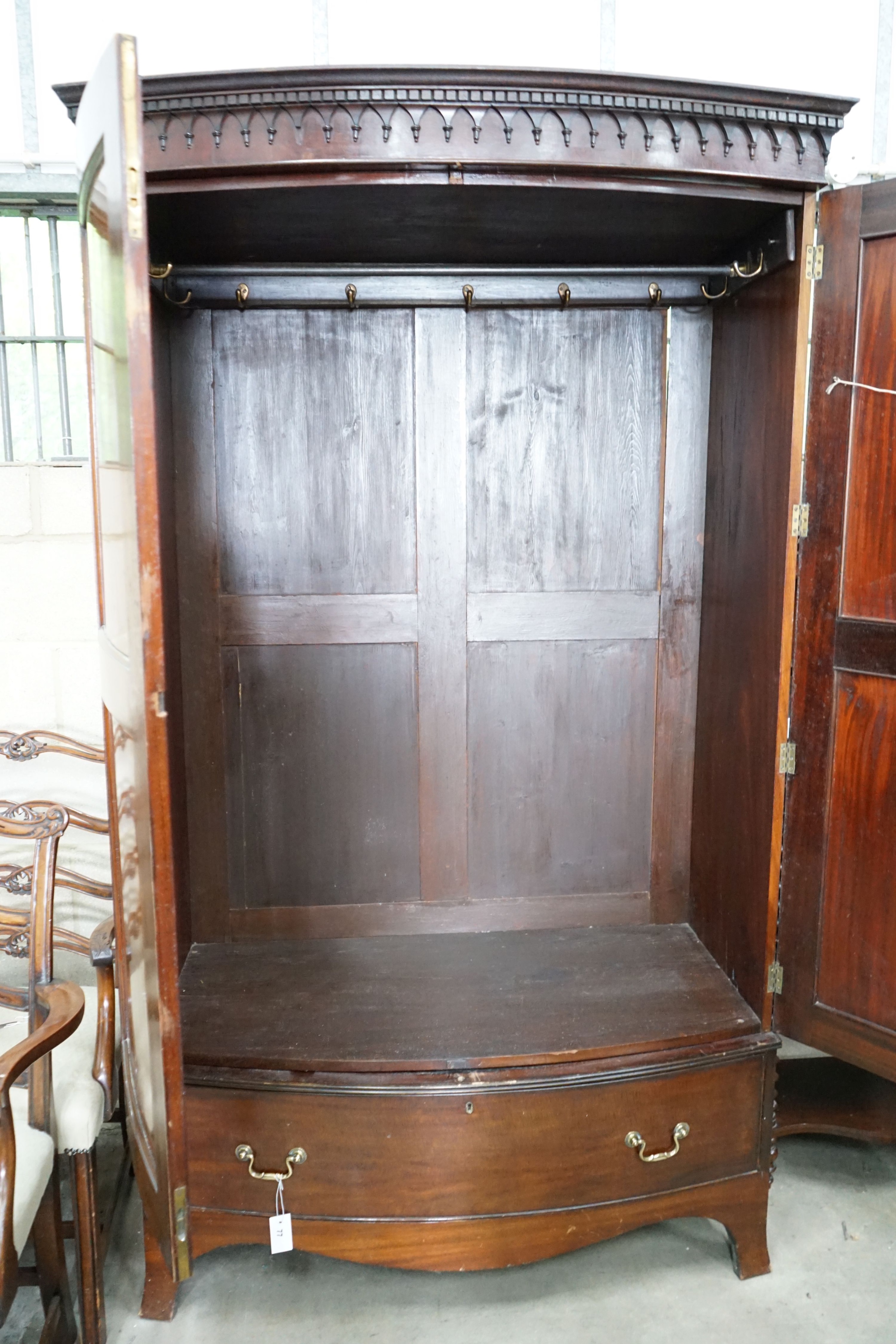An early 20th century George III style mahogany bowfront wardrobe, with hanging space and one long drawer, length 122cm, depth 64cm, height 206cm